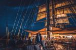 Guests sit on the deck of the ship Sea Cloud and enjoy the evening