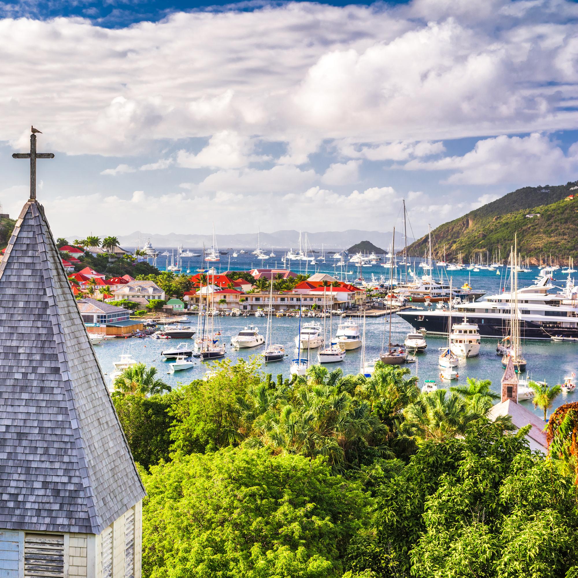 A beautiful view of a Caribbean town and ship at bay from behind Saint Barthelemy's Anglican Church on Saint Barthelemy.