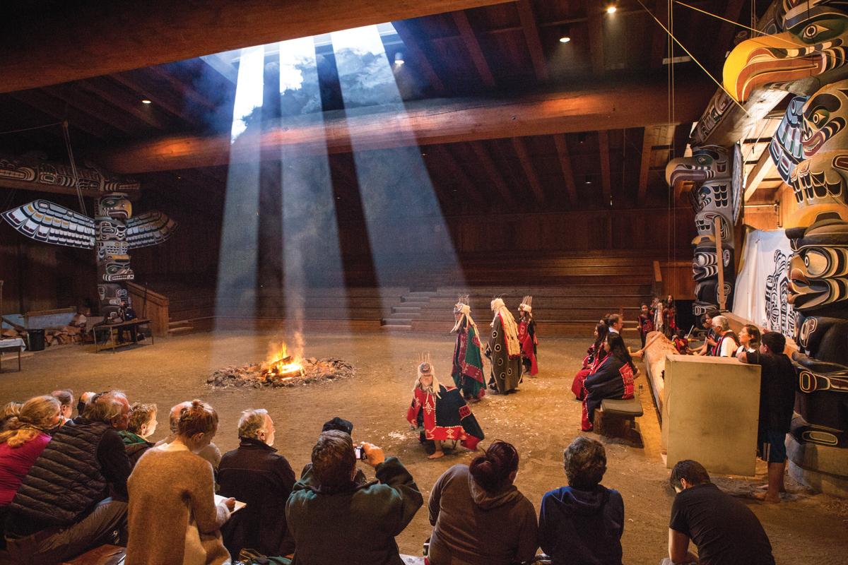 Guests watch the local Kwakwaka'wakw people perform at a cultural event in the big house in Alert Bay, Cormorant Island, British Columbia, Canada.