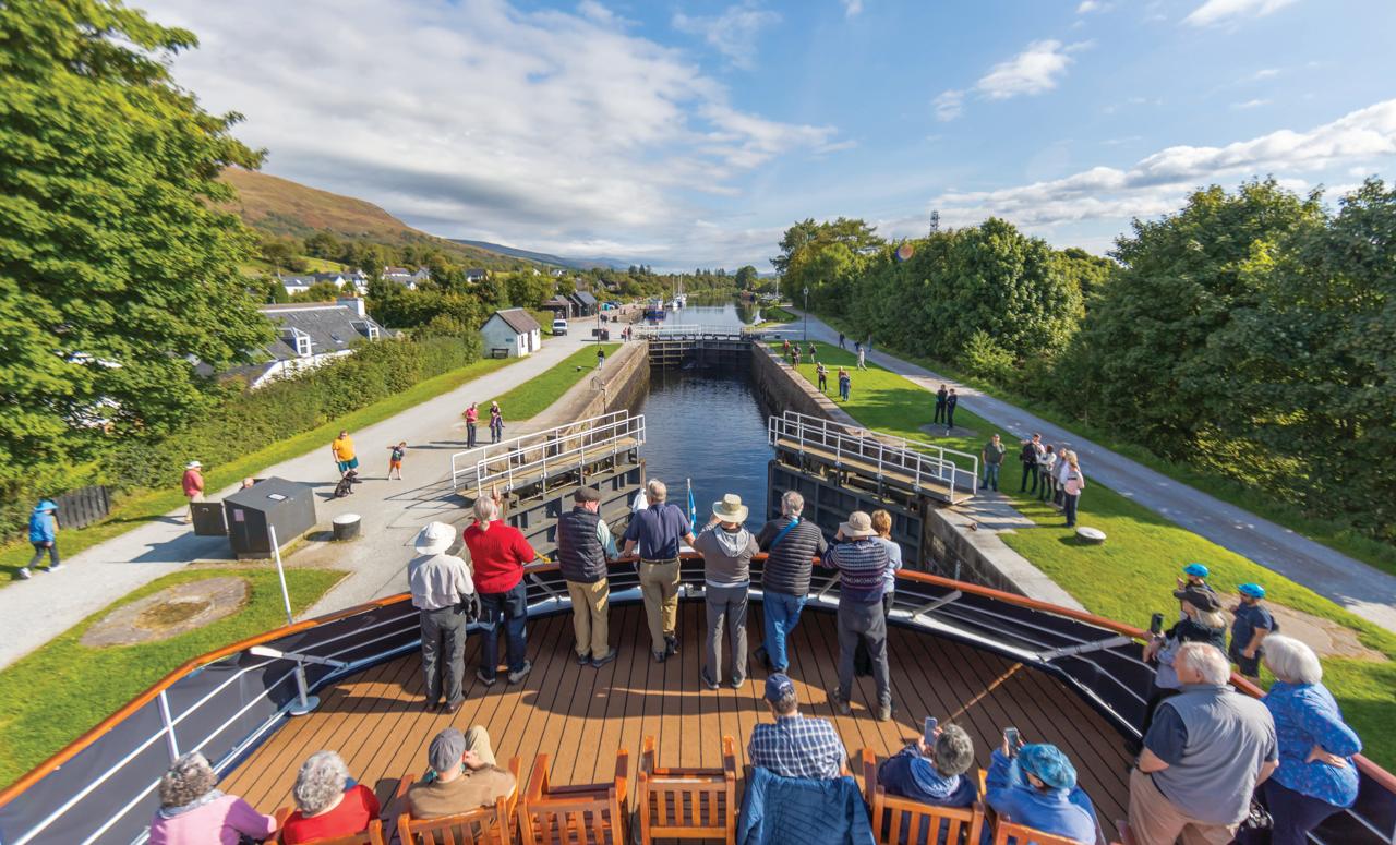 Guests watch on as Lord of the Glens transits the lock system on the Caledonian Canal, Scotland.