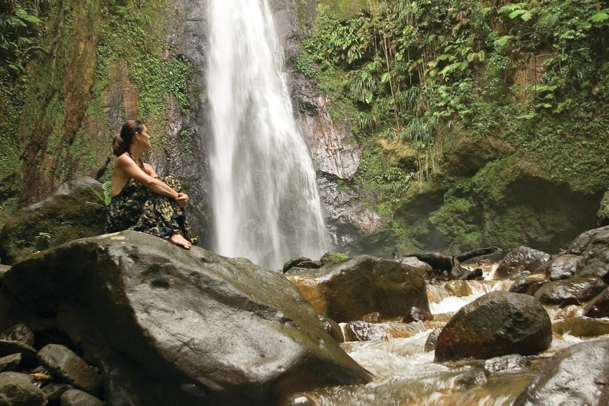 Traveler, Maria Lindblad,  sits and enjoys a waterfall in Dominica, Caribbean