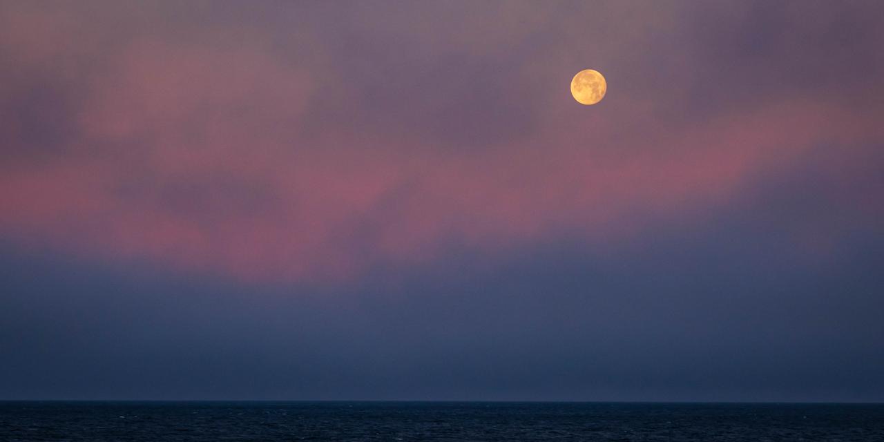 The moon high in the sky at sunrise, Storefjord, Greenland