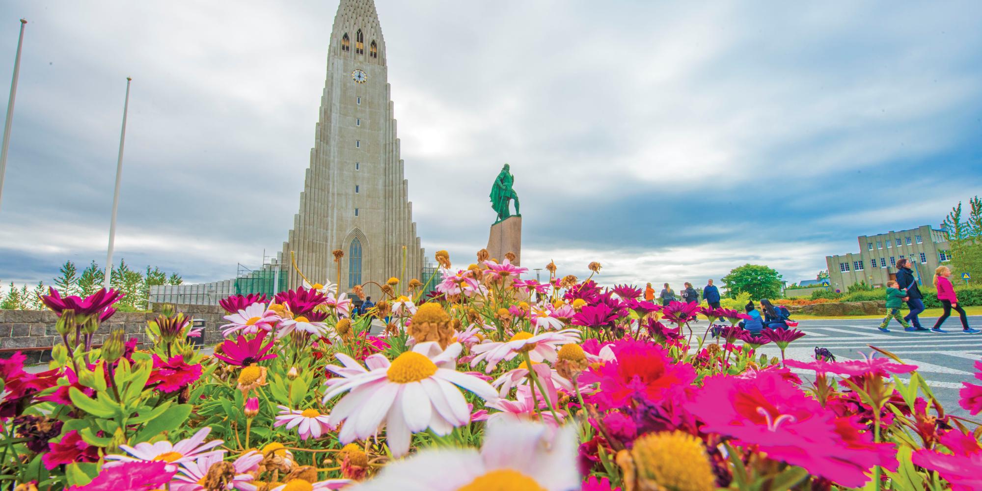 Beautiful summer flowers and guests in front of the Hallgrímskirkja Cathedral, Reykjavik, Iceland