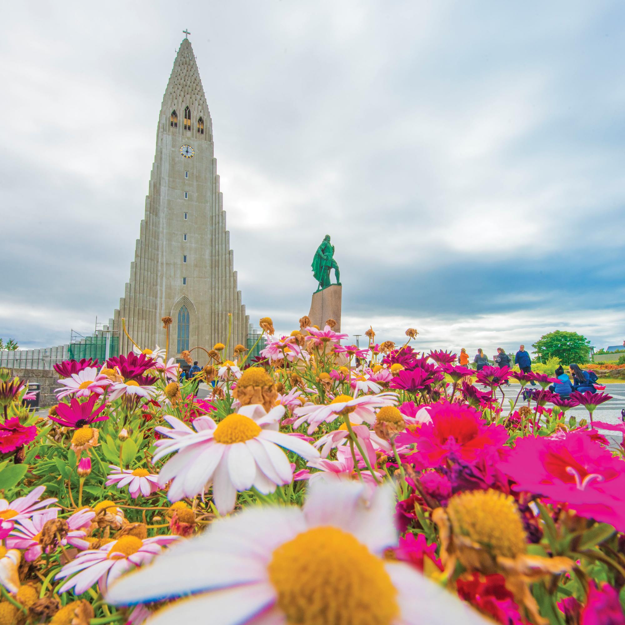 Beautiful summer flowers and guests in front of the Hallgrímskirkja Cathedral, Reykjavik, Iceland