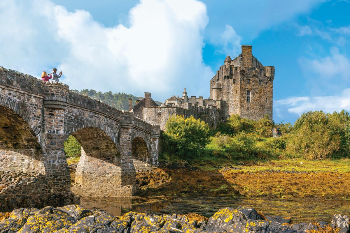 Guests take photographs of Eilean Donan Castle, a favorite guest location, in Loch Duich, Highland, Scotland.