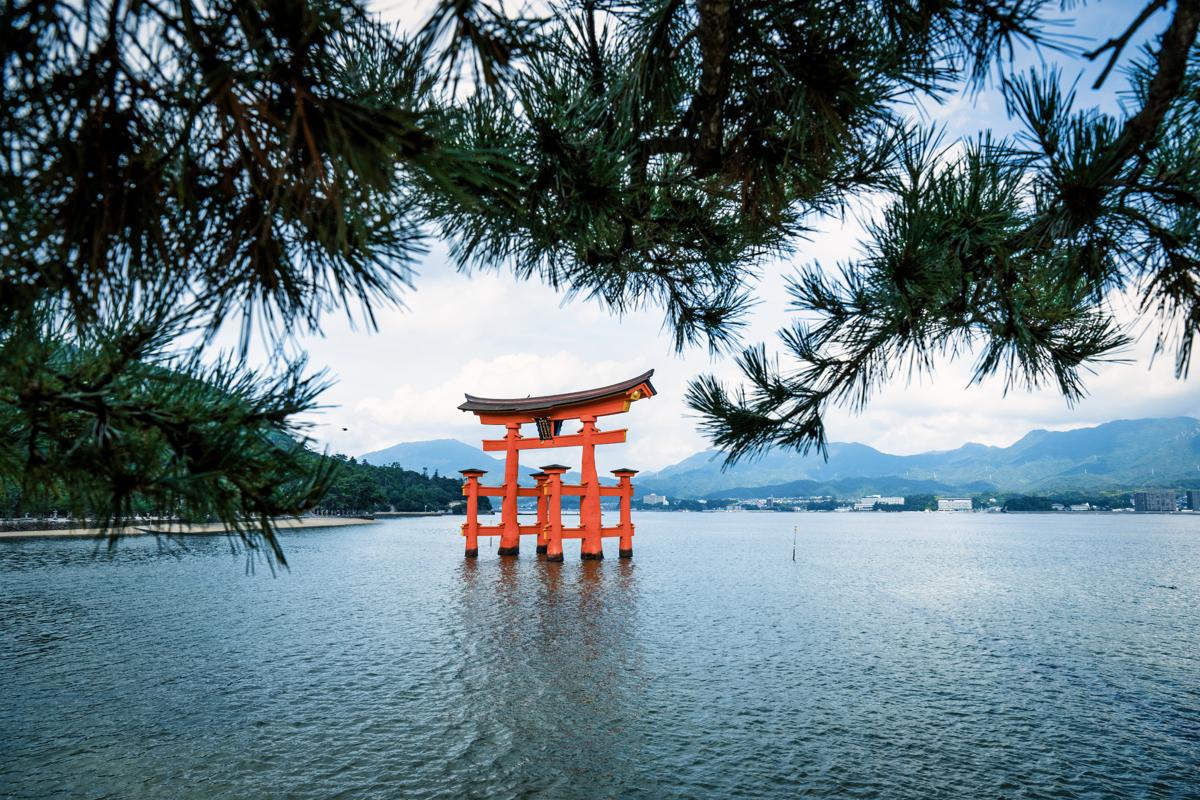 Itsukushima, or Miyajima, a serene island in Hiroshima Bay, Japan. Home to ancient temples and a famous partially submerged orange Great Torii Gate at high tide, marking the entrance to the 12th-century Itsukushima Shrine.