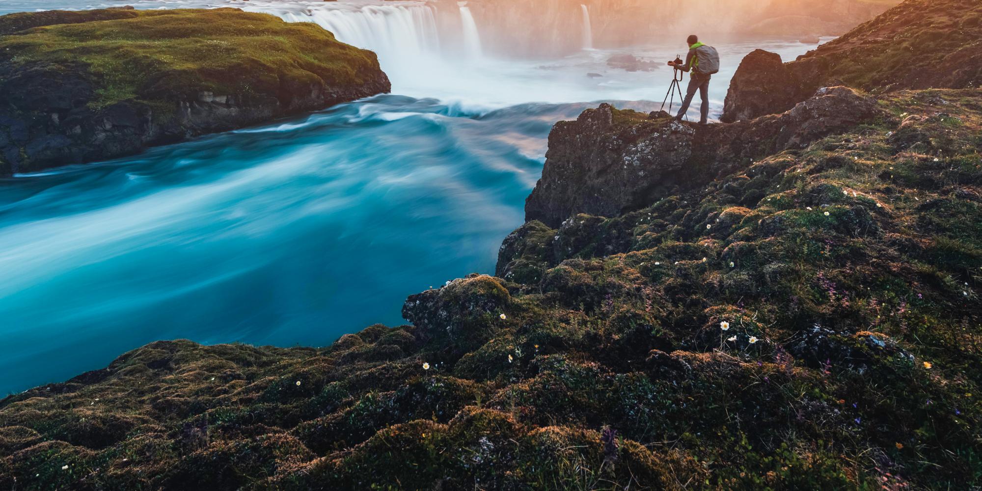 A guest photographs Godafoss waterfall on the Skjalfandafljot river, Iceland.