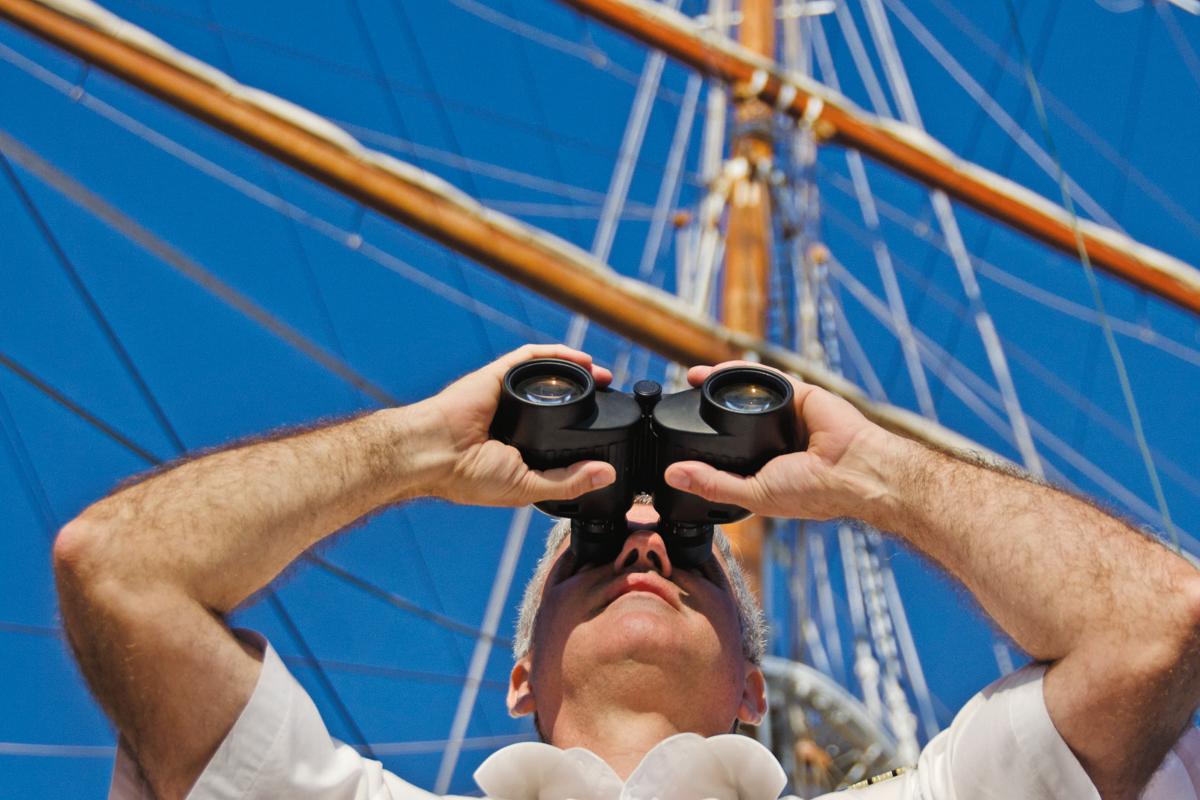 A guest using binoculars on the ship Sea Cloud