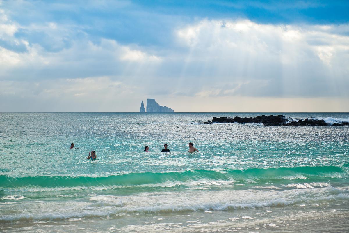 Guests swimming with view of Kicker Rock in the distance.