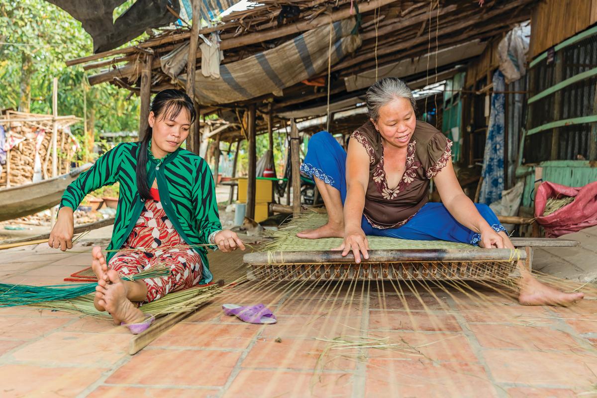 Women weaving rattan mats on Binh Thanh Island at Sadec, Mekong River Delta, Vietnam