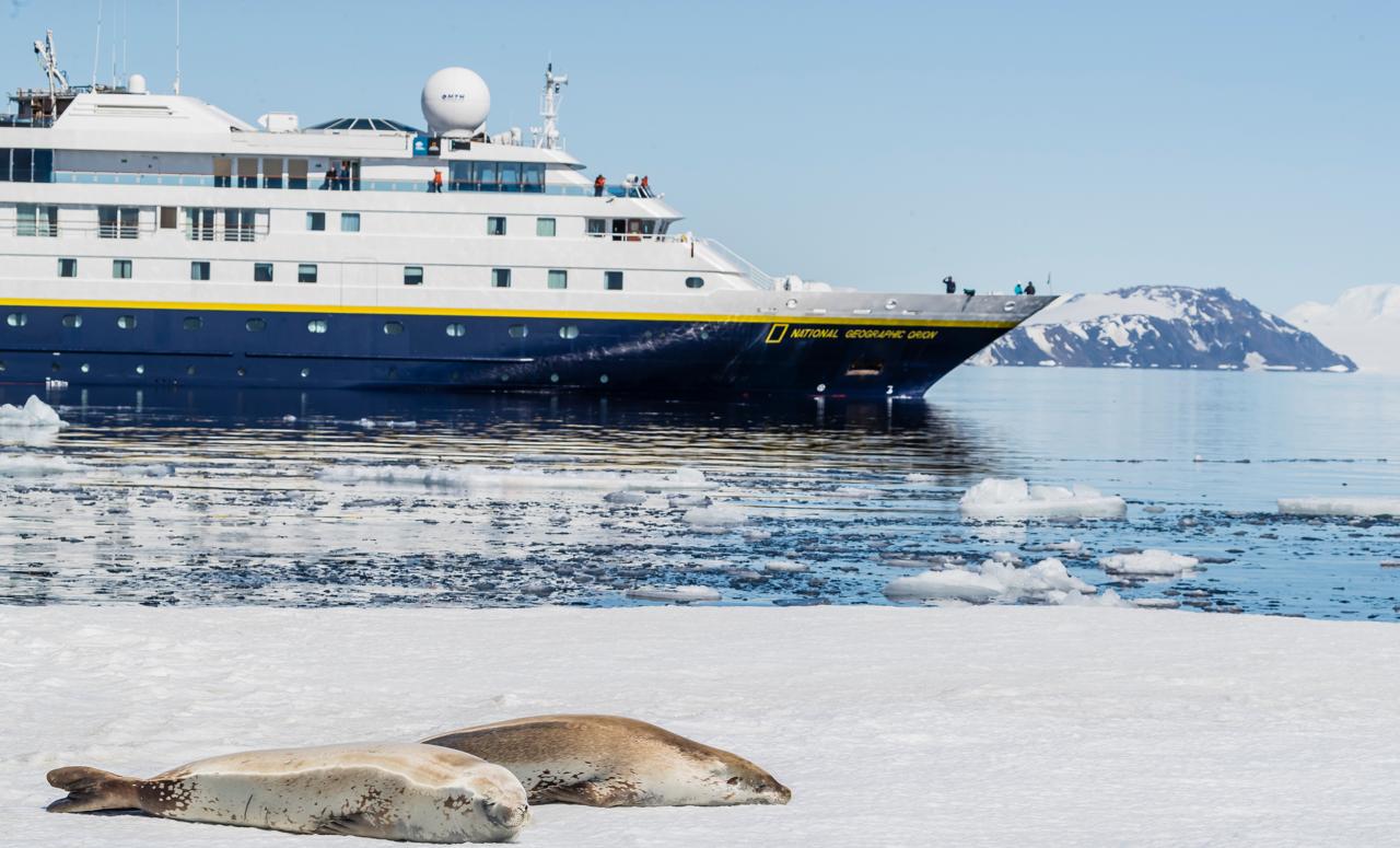 Crabeater seals on pack ice and the ship National Geographic Orion in Duse Bay, Weddell Sea, Antarctica.