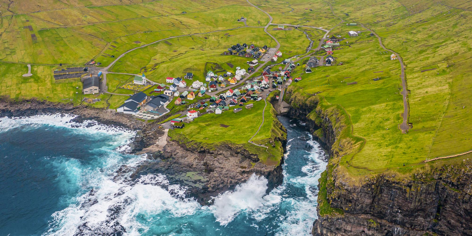 Natural harbour gorge in Gjogv village aerial view, Faroe islands, Europe