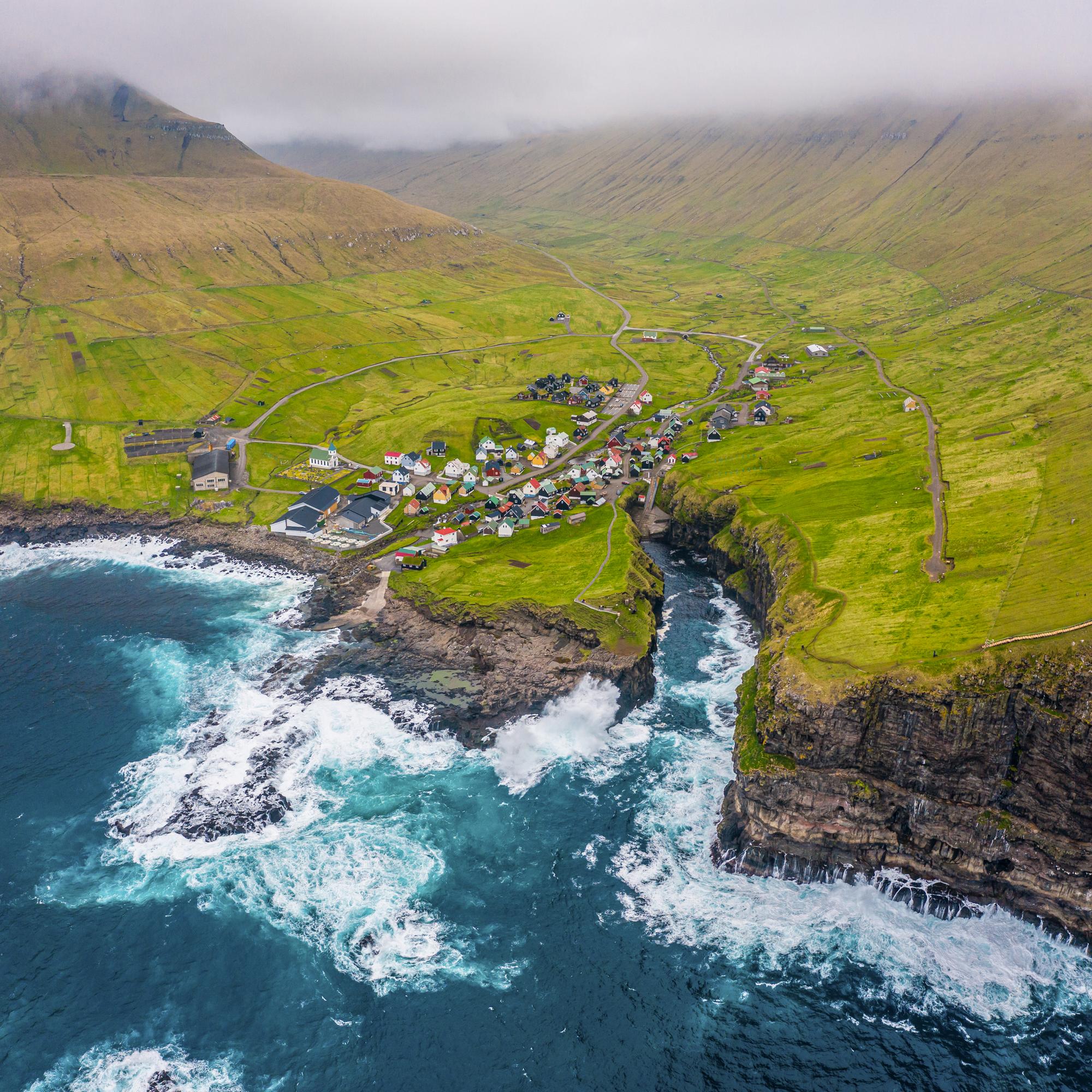 Natural harbour gorge in Gjogv village aerial view, Faroe islands, Europe