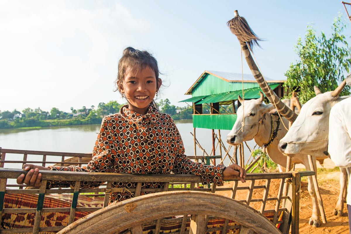 A young villager from Kampong Tralach District on Cambodia’s Tonle Sap River greets guests who will take her family’s oxcart to their village