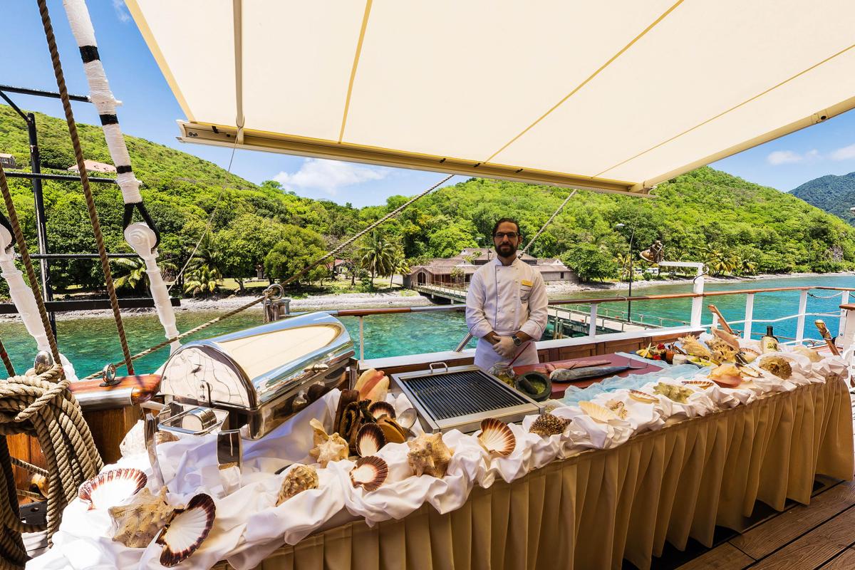 Steward serves food on the deck  of  Sea Cloud II 