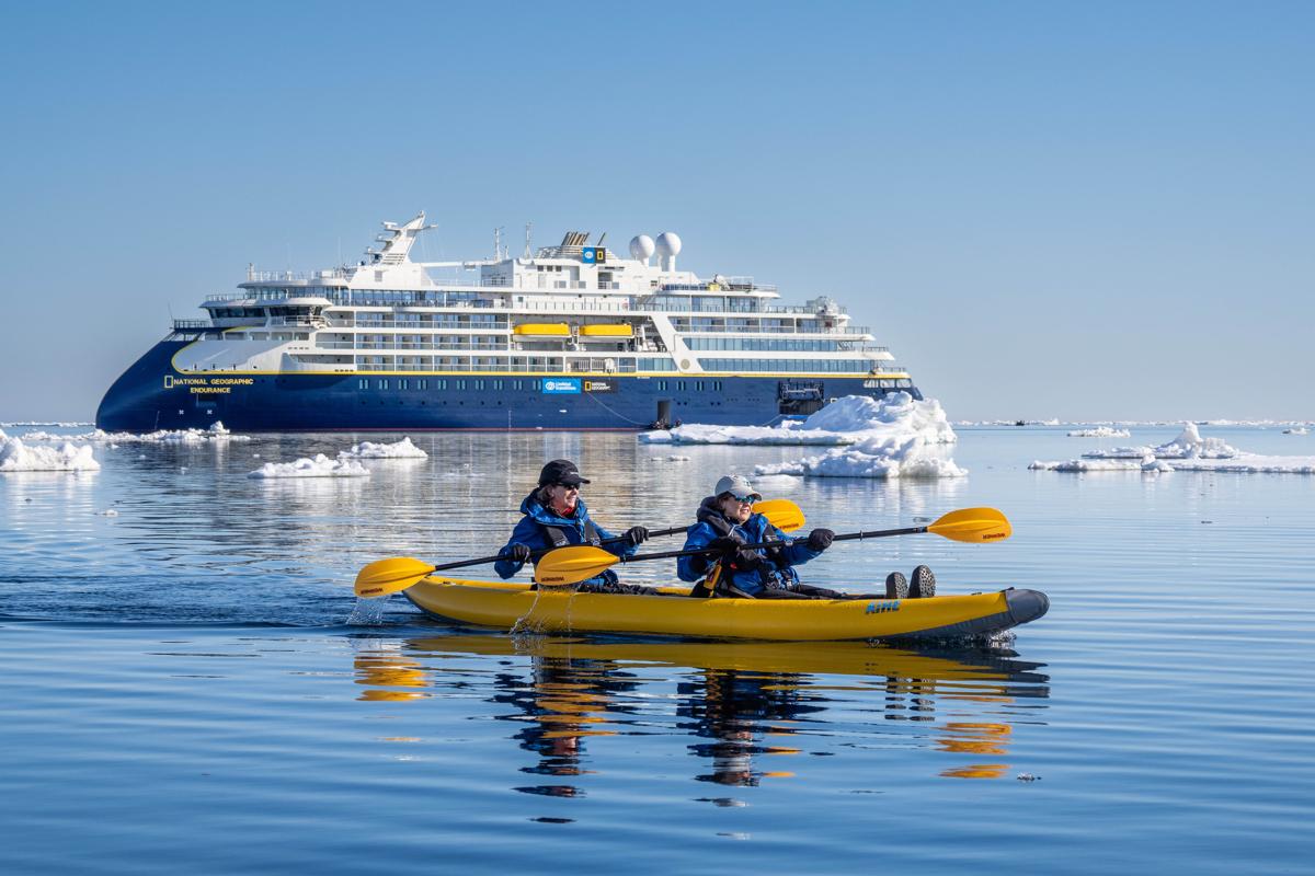 Guests from the National Geographic Endurance kayaking in ice off the island of Edge Island, Svalbard, Norway..